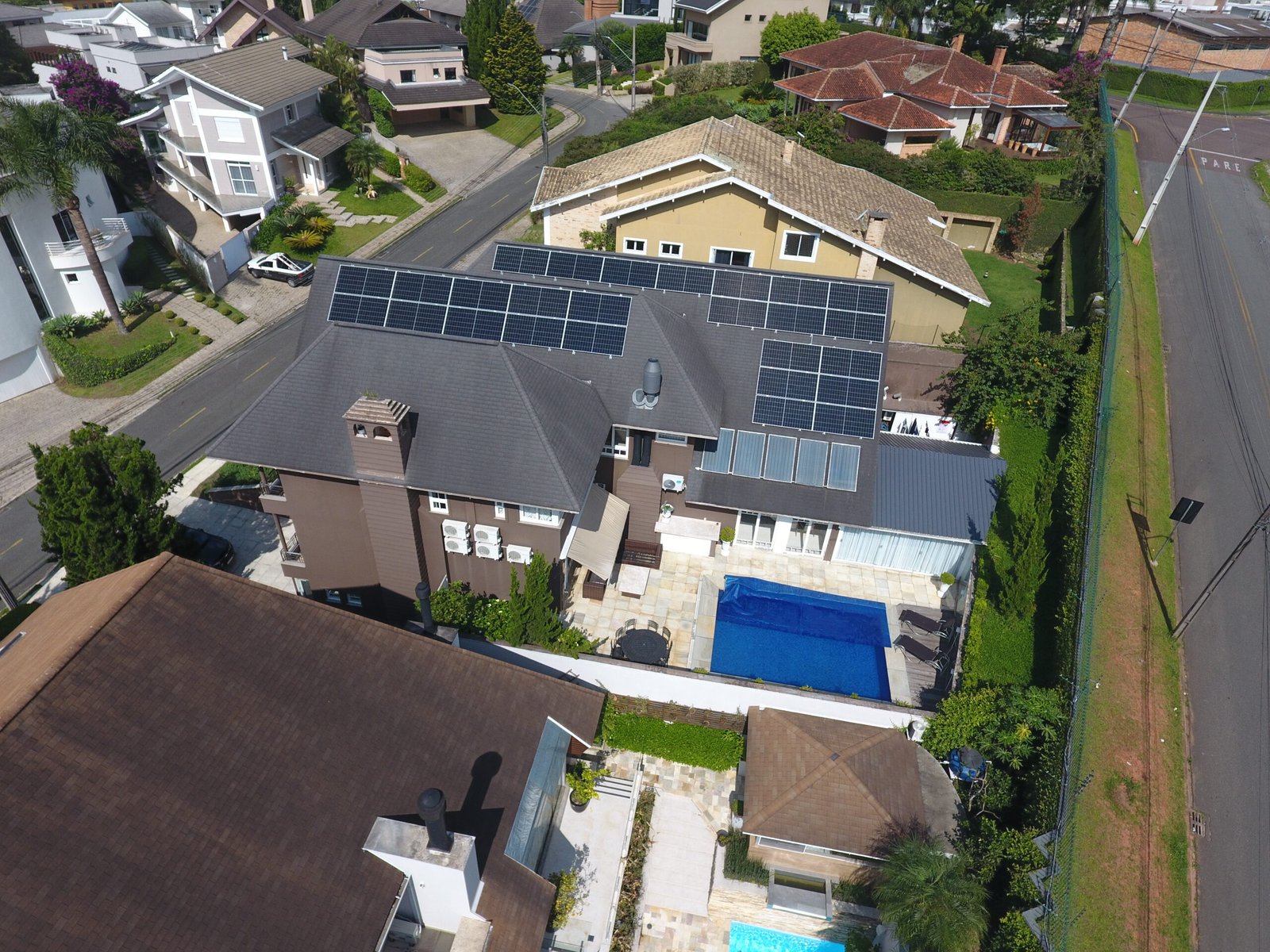 Vista aérea de casas em condomínio residencial com painéis solares instalados nos telhados